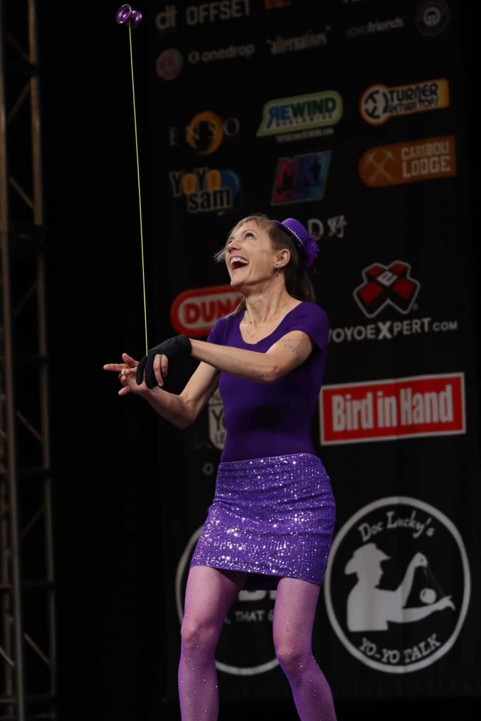 Jen Joy performing on the main stage at a YoYo competition, purple yoyo suspended mid-air