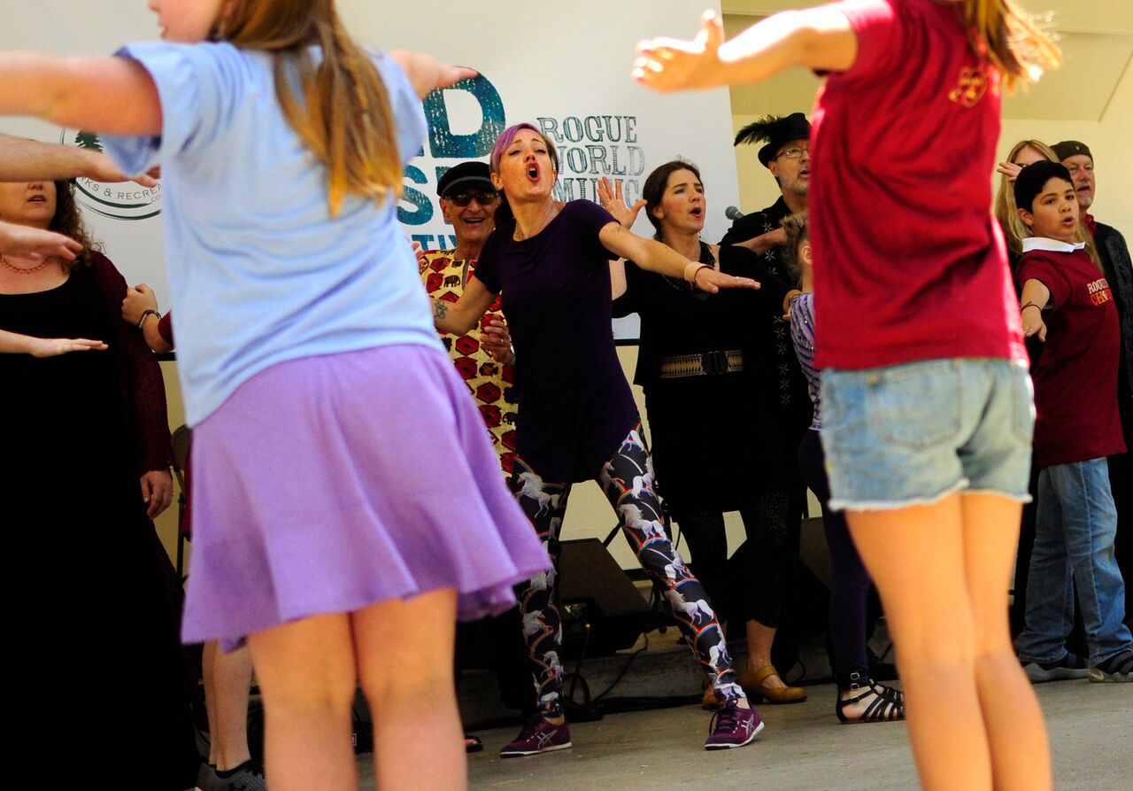 Jenifer leading a community sing with Rogue World Music