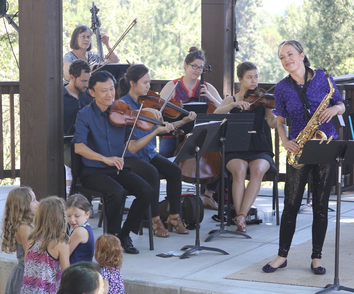 Jenifer performing Saxophonic Spectacular with the Britt orchestra and children watching