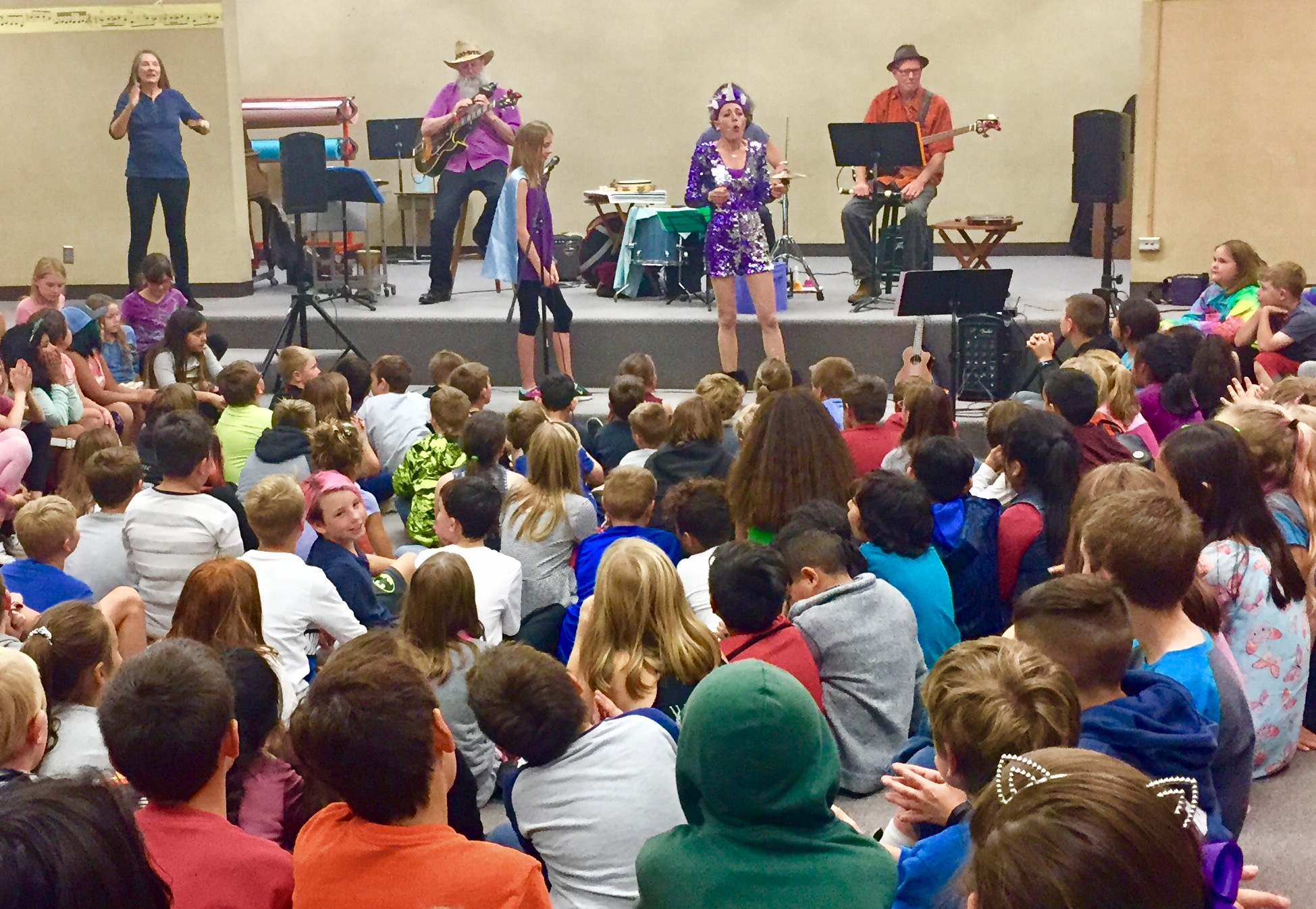 Jenifer performing an educational school assembly for a large audience of students
