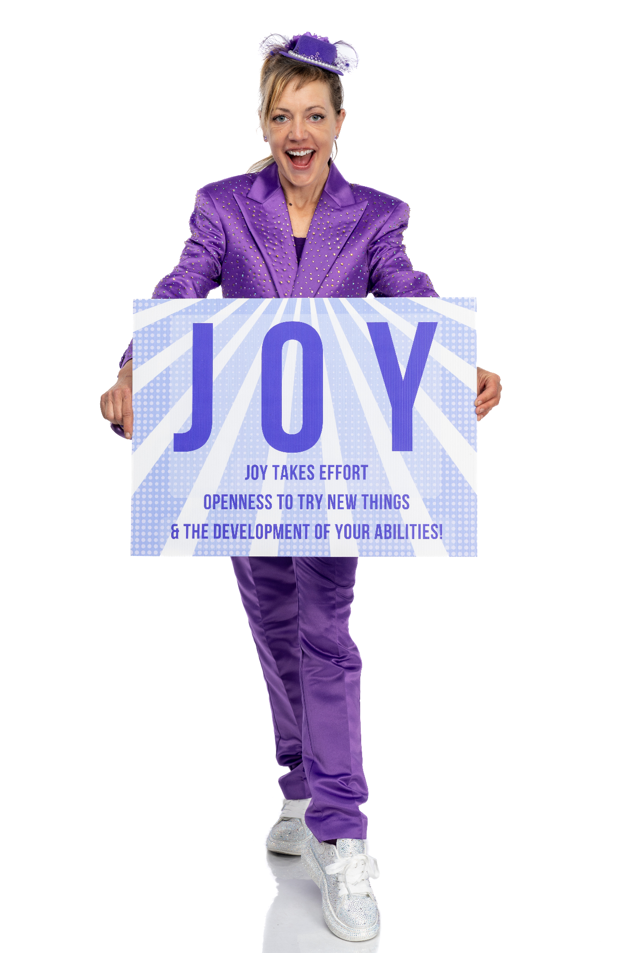 Jenifer Joy holding a sign that says JOY — Joy takes effort, openness to try new things, and the development of your abilities